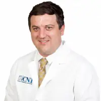 A man in white lab coat and tie.